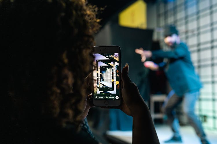 Woman Hand Holding Cellphone And Taking Pictures Of Posing Man