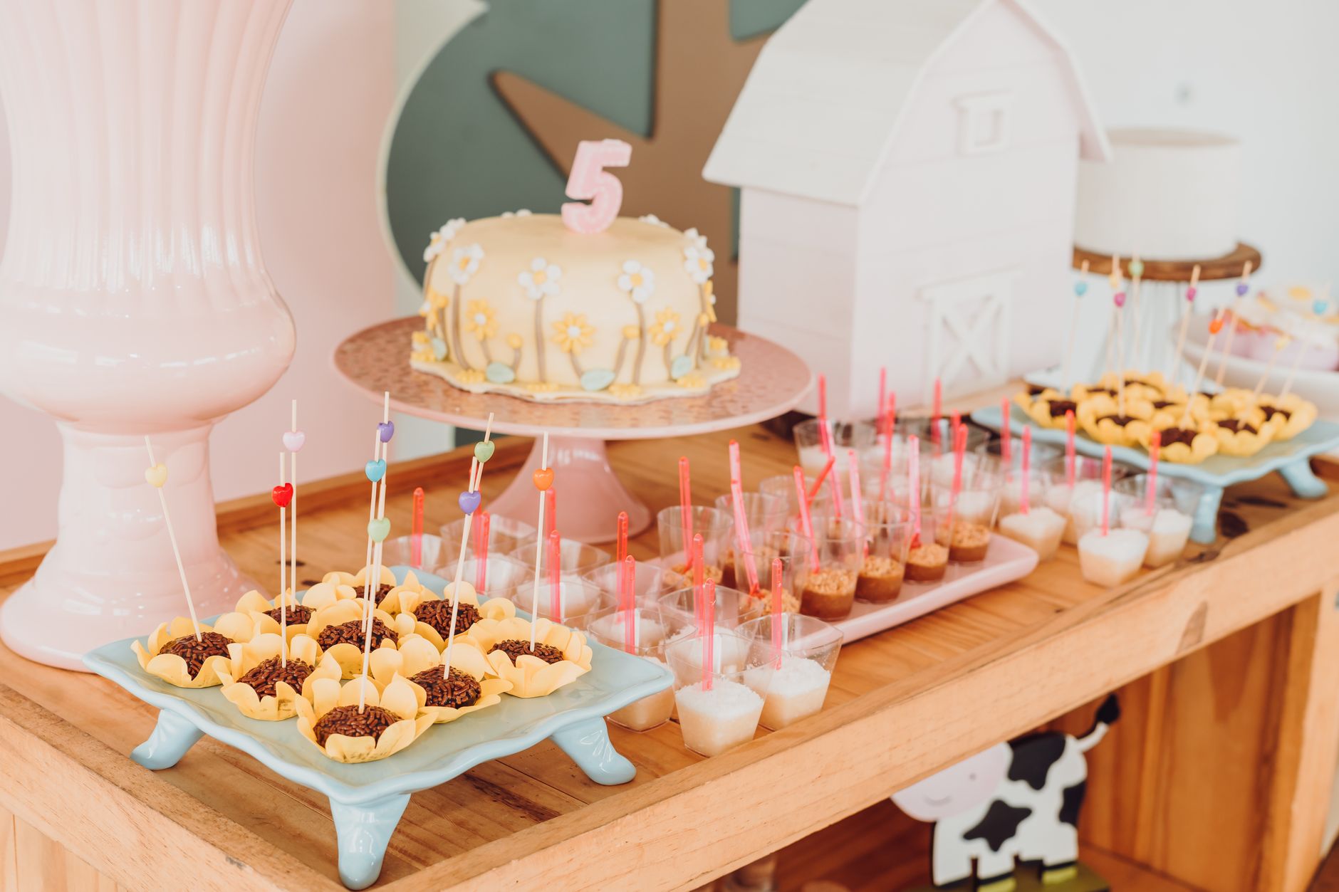 A vibrant dessert table setup for a child's birthday party with a number 5 cake and sweet treats.