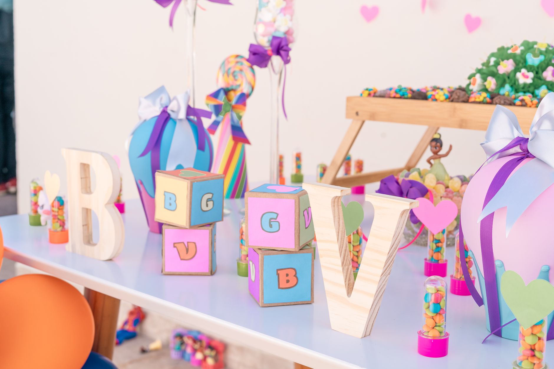 Vibrant party setup featuring letter blocks and colorful decorations on a table.