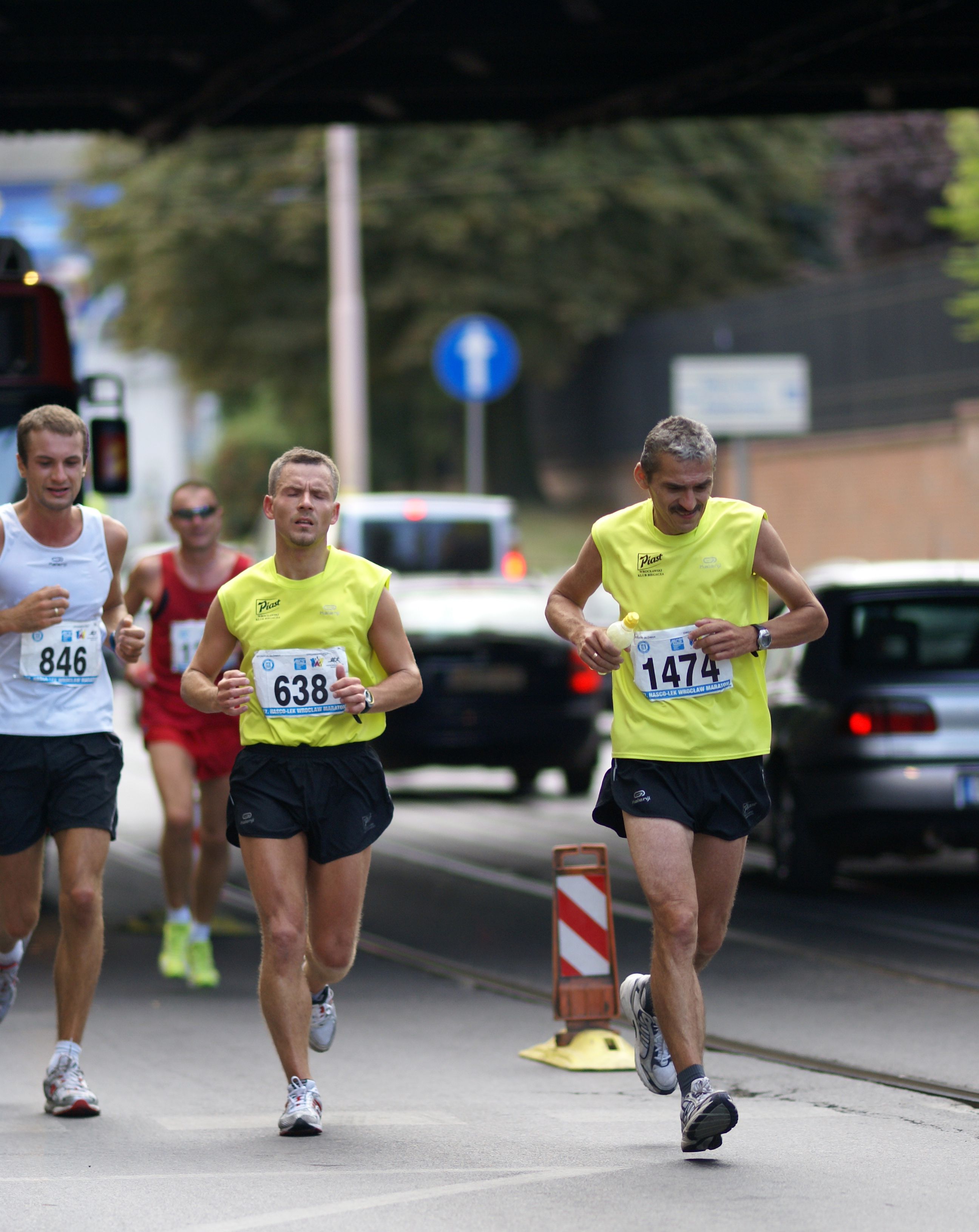 Energetic marathon runners competing on a city street, displaying athletic endurance.