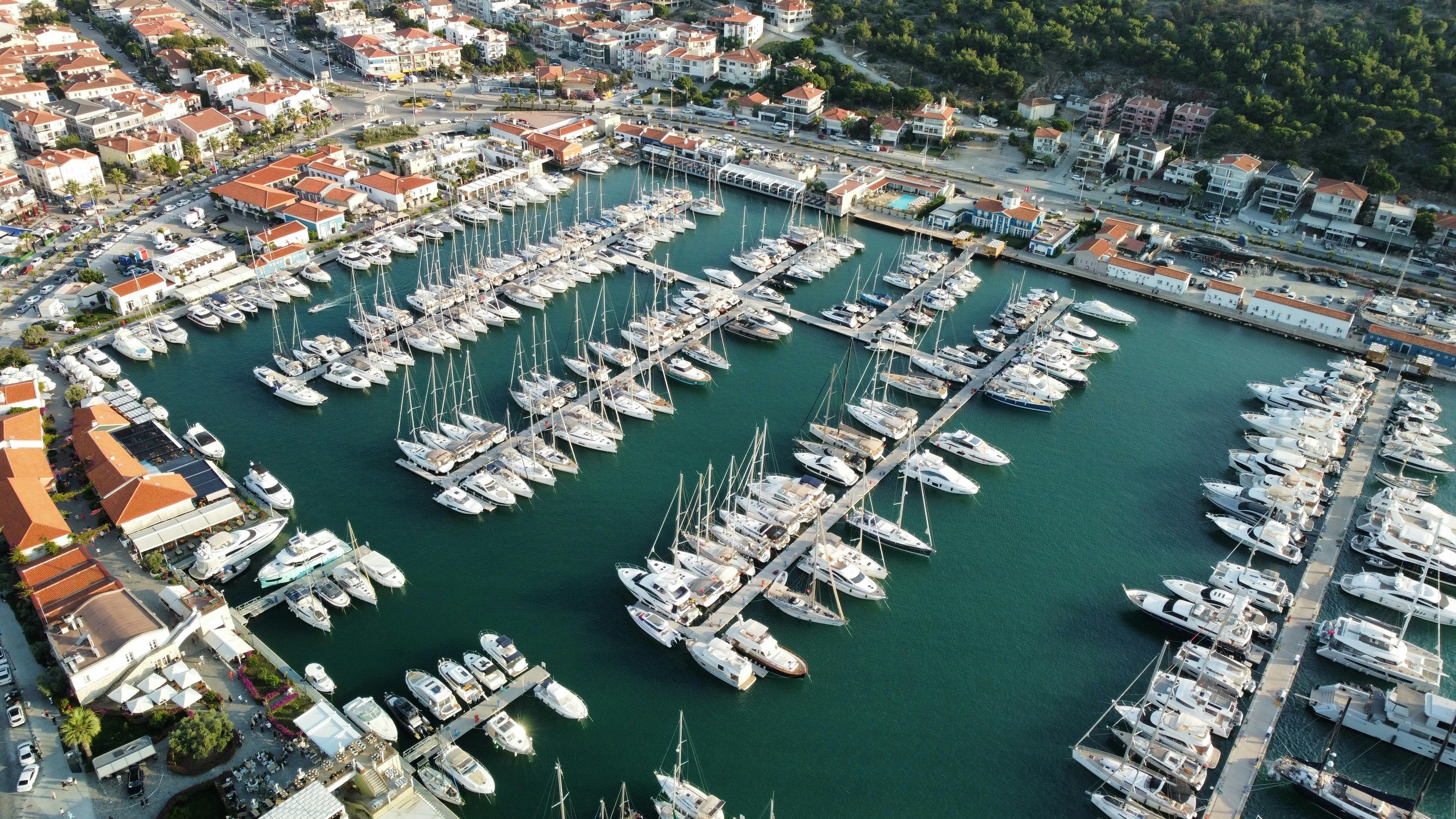 Stunning aerial view of a bustling marina with yachts and surrounding urban landscape.
