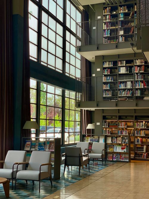 Free A bright, modern library interior with high ceilings, bookshelves, and seating area. Stock Photo