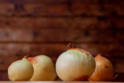 Onions on a wooden table with a wooden background