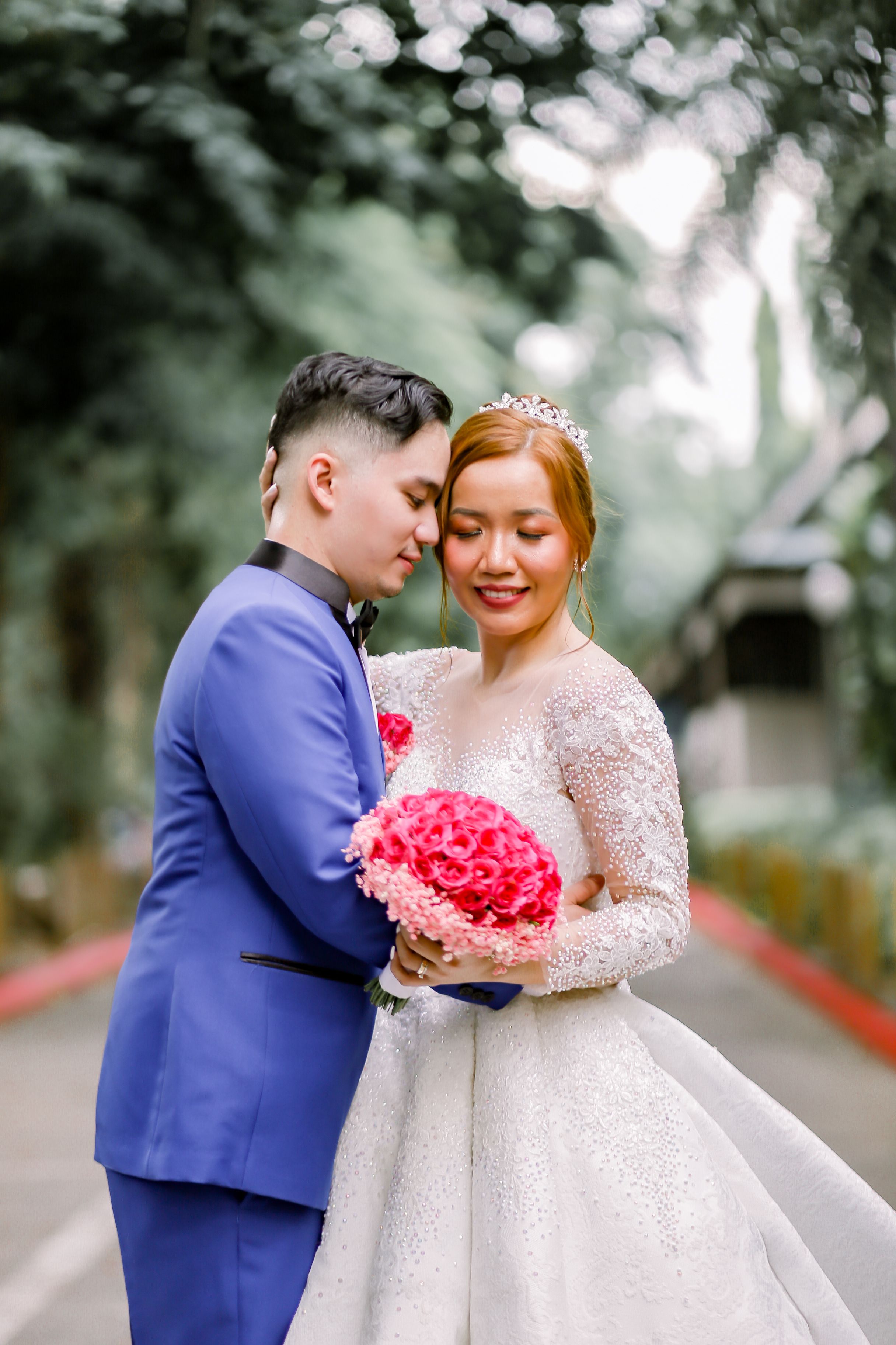 A beautiful bride and groom embrace in an outdoor setting, celebrating their special day.