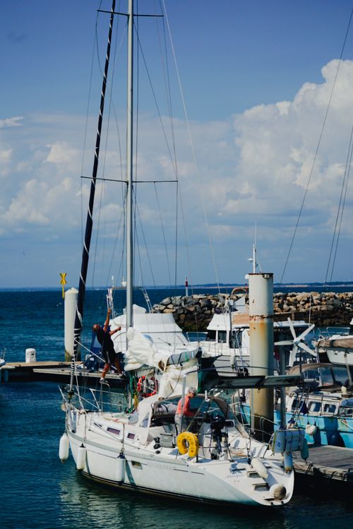 Free A tranquil marina scene with sailboats docked under a clear blue sky, perfect for travel enthusiasts. Stock Photo