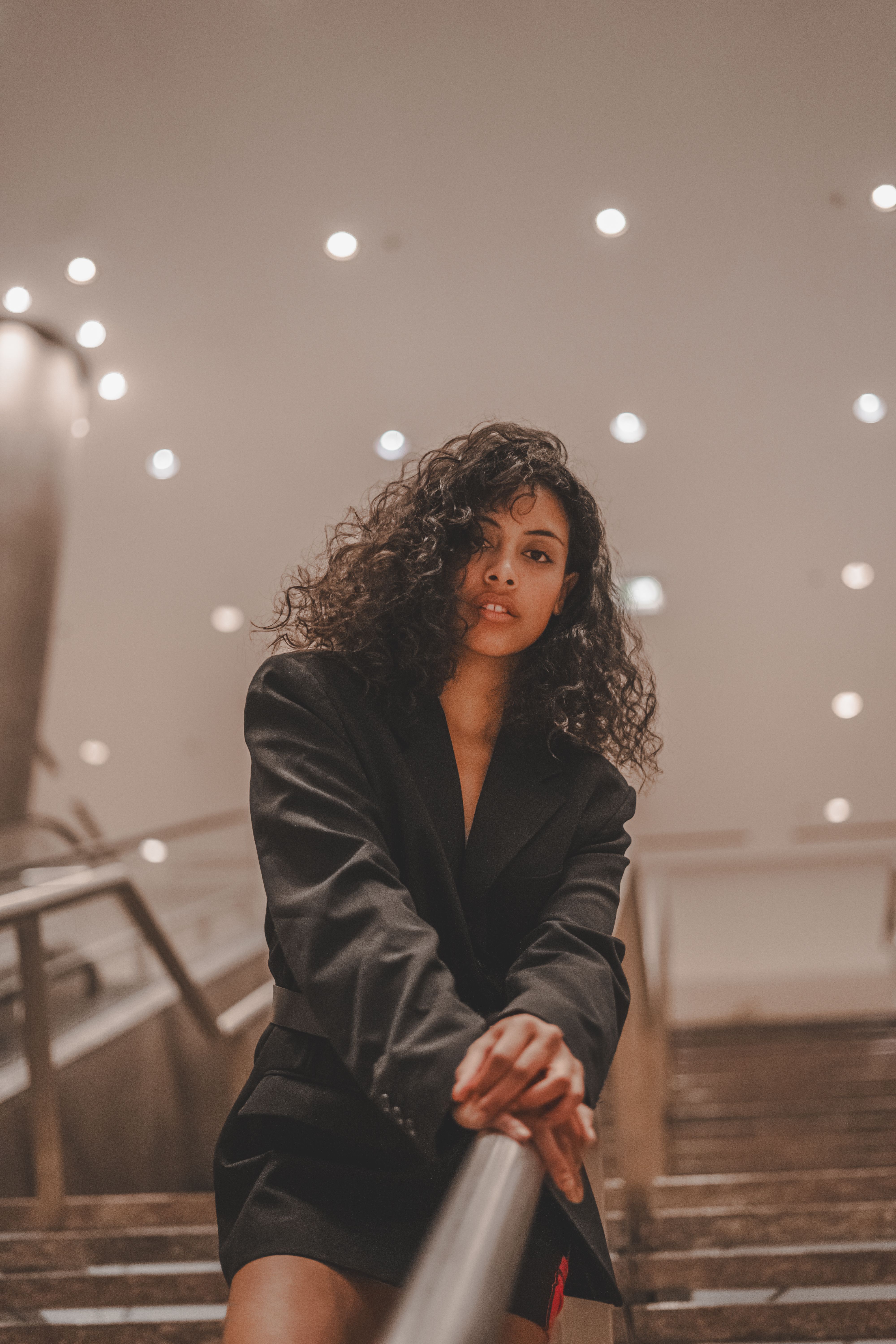 Woman in a Black Jacket Standing on the Stairs · Free Stock Photo
