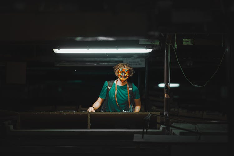 Man In A Mask Standing Under The Light 