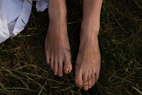 Free Close-up of a woman's bare feet in the grass, conveying a natural and serene summer vibe. Stock Photo