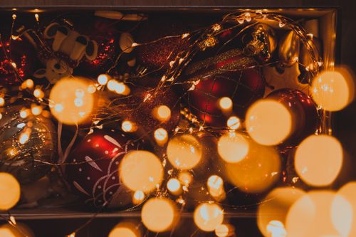 Free Vibrant Christmas ornaments adorned with warm bokeh lighting, exuding festive cheer. Stock Photo