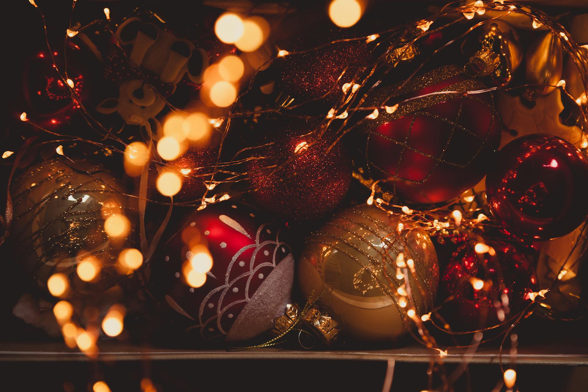 Festive Christmas ornaments surrounded by glowing fairy lights creating a warm holiday ambiance.