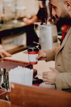 Adult man in a cafe holding a coffee cup, Baku, Azerbaijan.