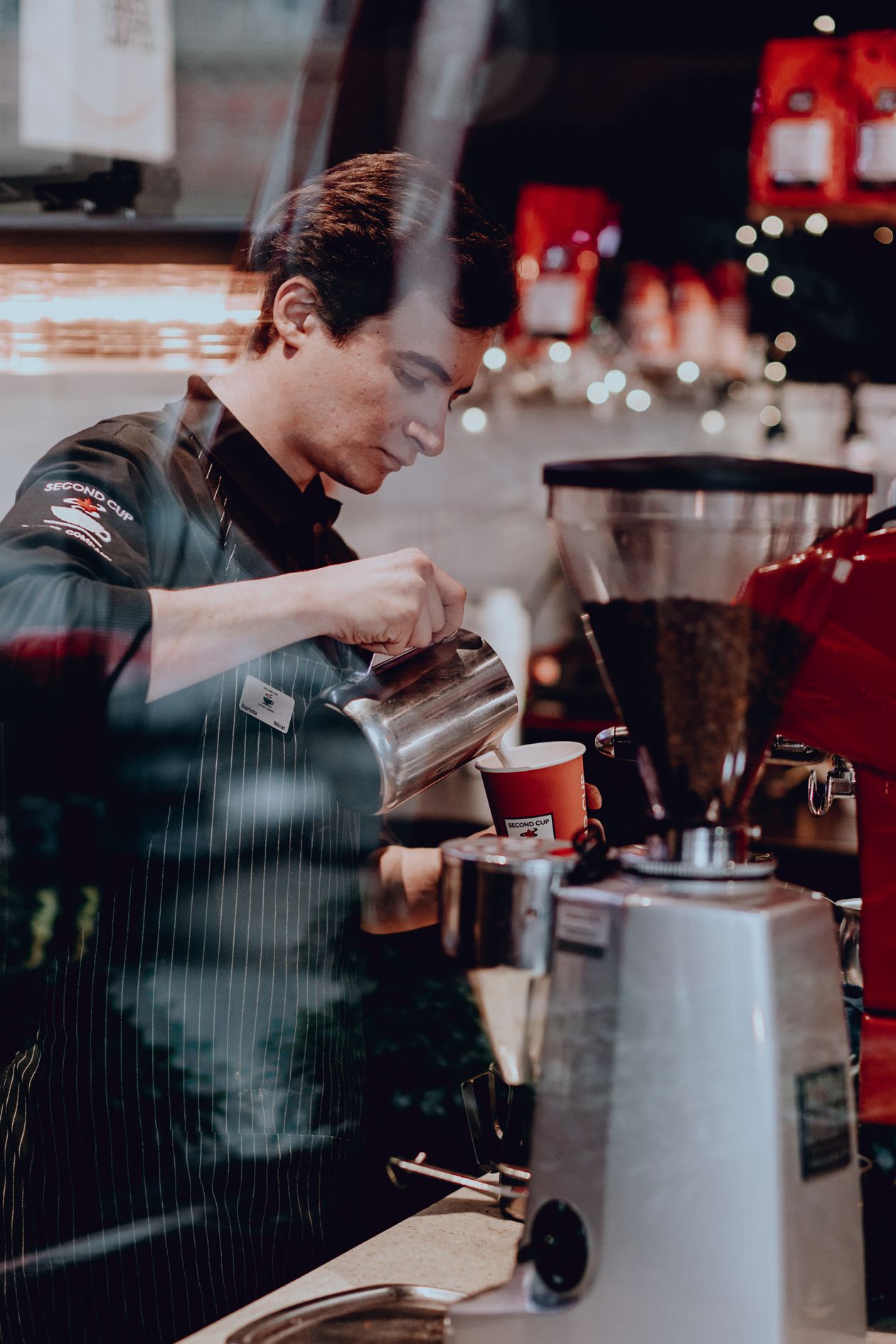 Barista pouring coffee at a cafe — food service workers are among those most affected by minimum wage changes
