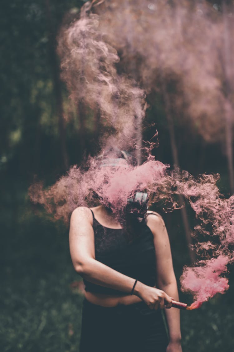 Woman In Gas Mask With Red Smoke Candle In The Forest