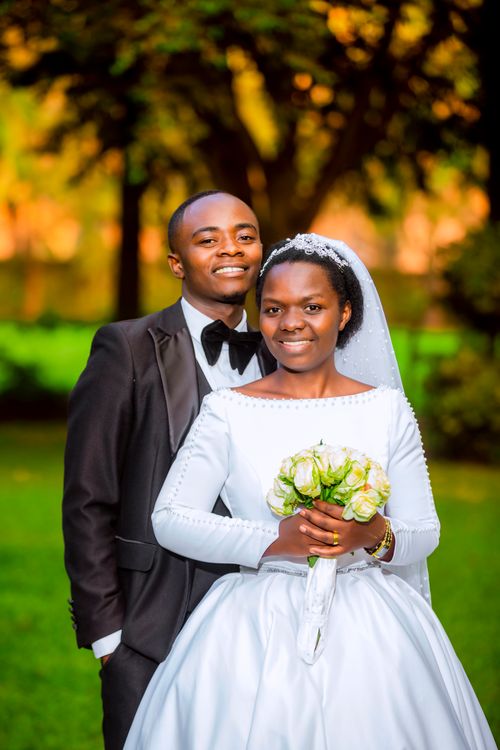 Free Happy couple posing outdoors in wedding attire, capturing a moment of love and celebration. Stock Photo