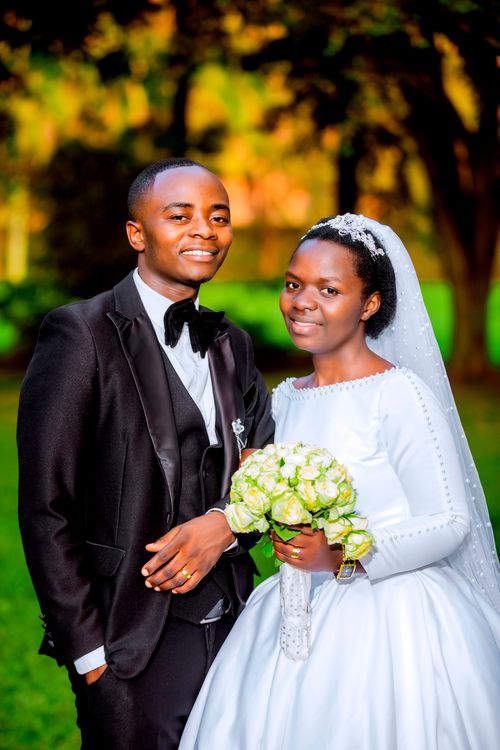 Free A vibrant outdoor portrait of a smiling bride and groom on their wedding day. Stock Photo