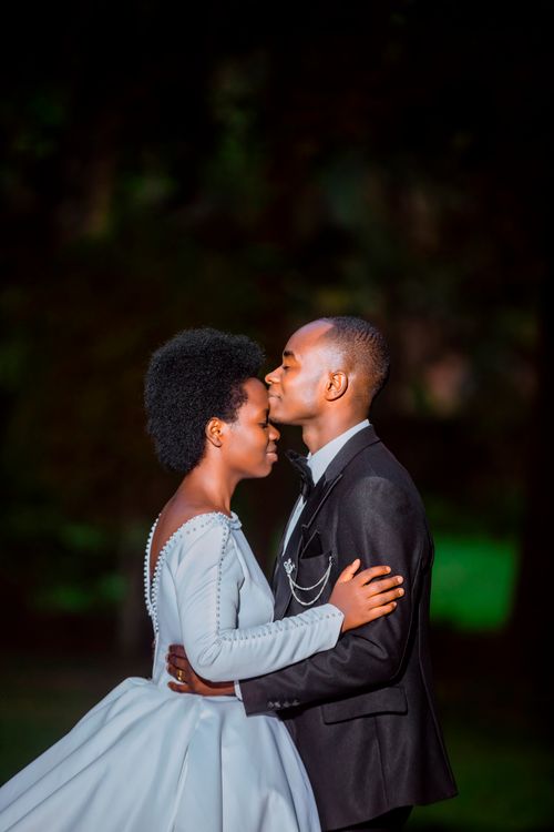 Free Bride and groom sharing a tender moment outdoors at night, capturing love and romance. Stock Photo