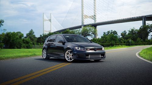 Modern Car on Road near Suspension Bridge