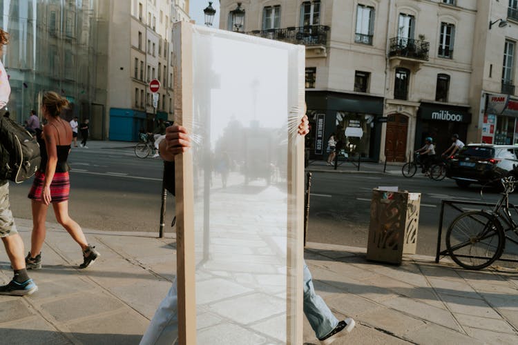 Man Carrying Big Mirror On City Street