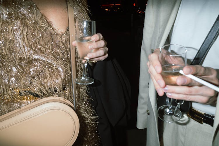 Close-up Of Man And Woman Drinking From Glasses On Party