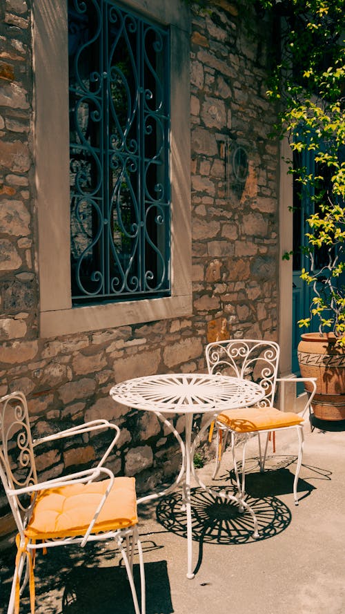 Table and Chairs by Stone Building Wall