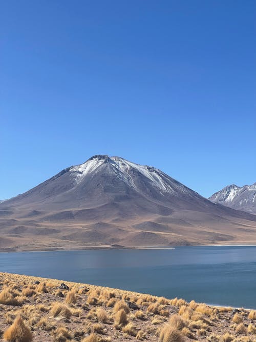 View of a Lake and Snowcapped Volcano on a Desert 