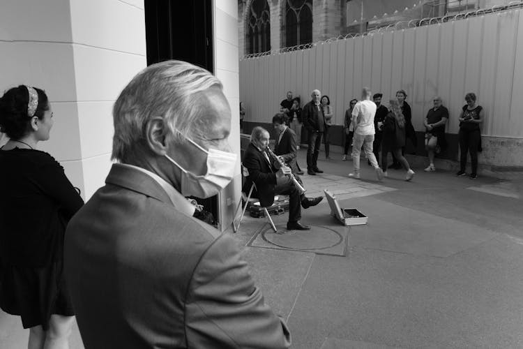 Old Man Playing On Musical Instrument On City Street