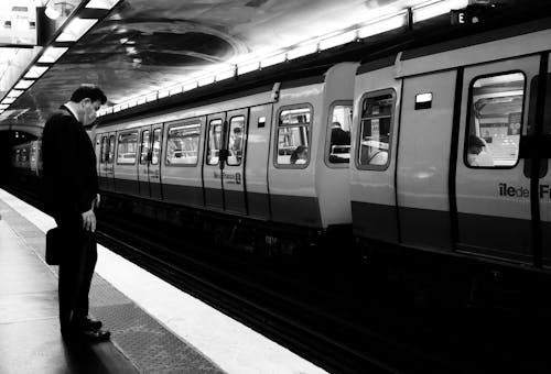 A Man Standing on a Platform at a Subway Station 