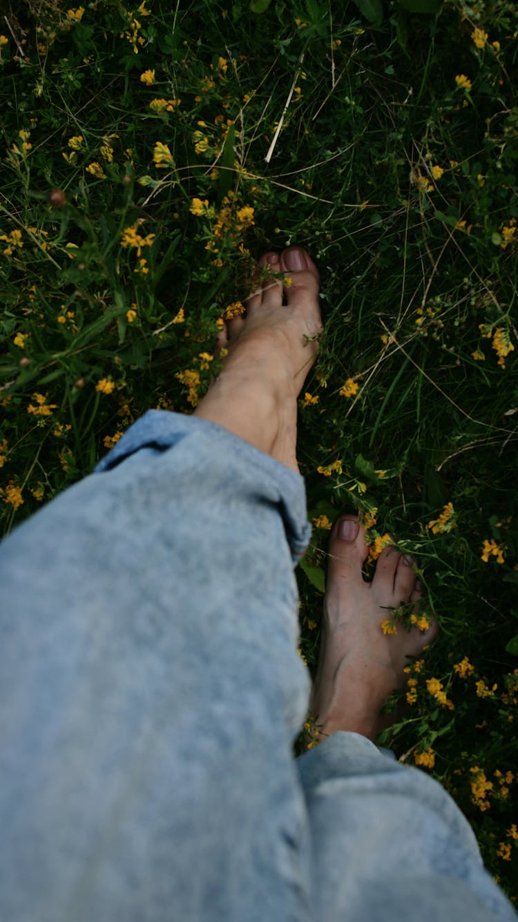 Woman Walking Barefoot On The Grass