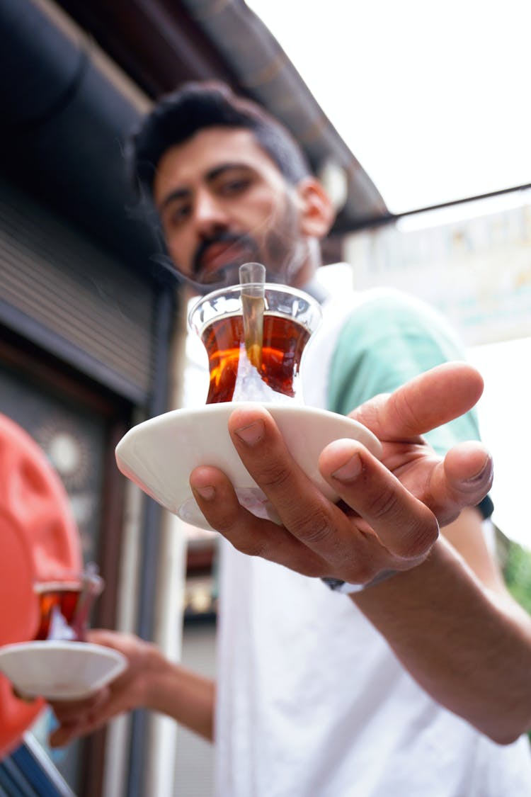 A Man Holding Tea In Ince Belli Glasses 