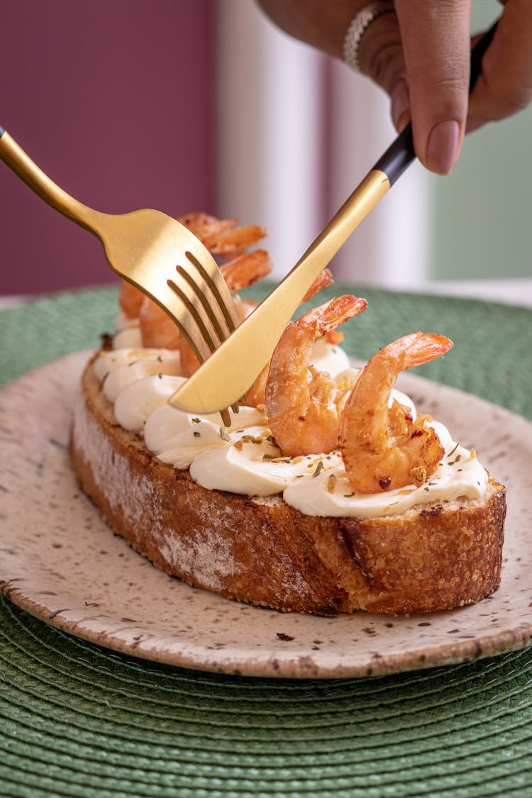 Golden Knife And Fork In Woman Fingers Over Cake On Plate