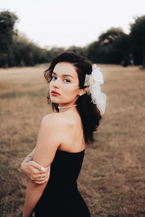 Young Brunette Woman Wearing a Black Bandeau Dress in a Countryside