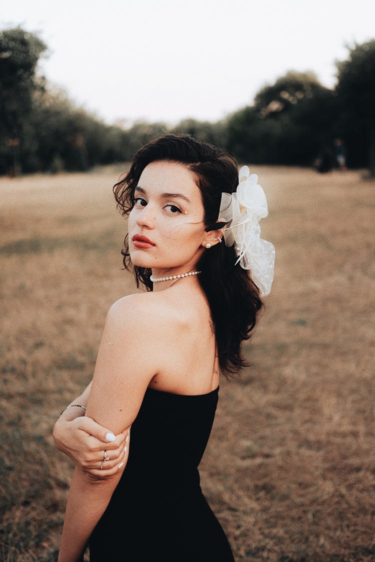 Young Brunette Woman Wearing A Black Bandeau Dress In A Countryside