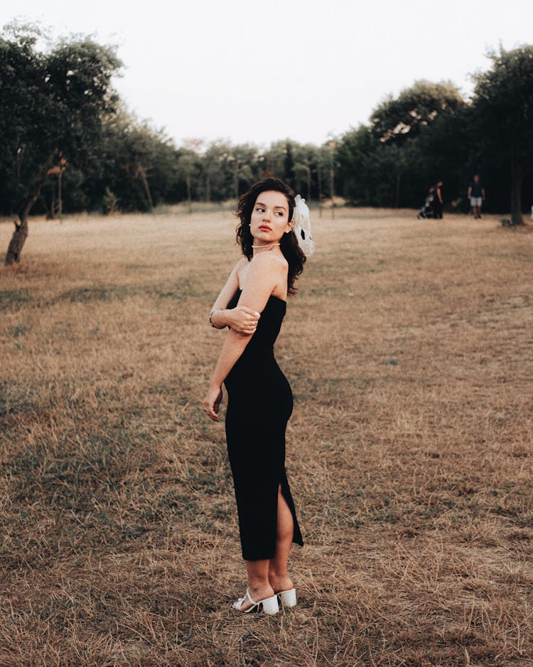 Beautiful Brunette Woman Wearing Black Bandeau Maxi Dress Posing In A Park