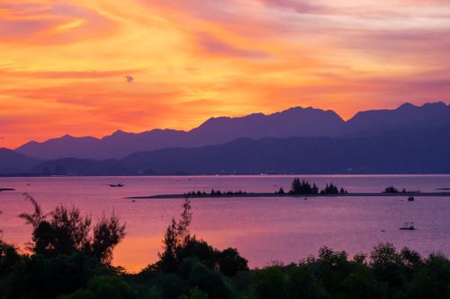 Free Stunning sunset over a lake with mountain backdrop, perfect for nature and travel themes. Stock Photo