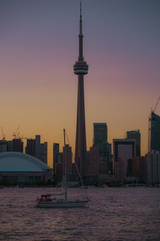 Stunning view of Toronto's skyline featuring the CN Tower at sunset with reflections in the water.
