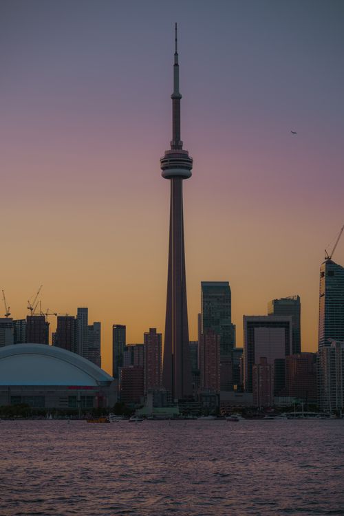 Free Capture of the Toronto skyline featuring the CN Tower against a dusky sky, viewed from the lake. Stock Photo