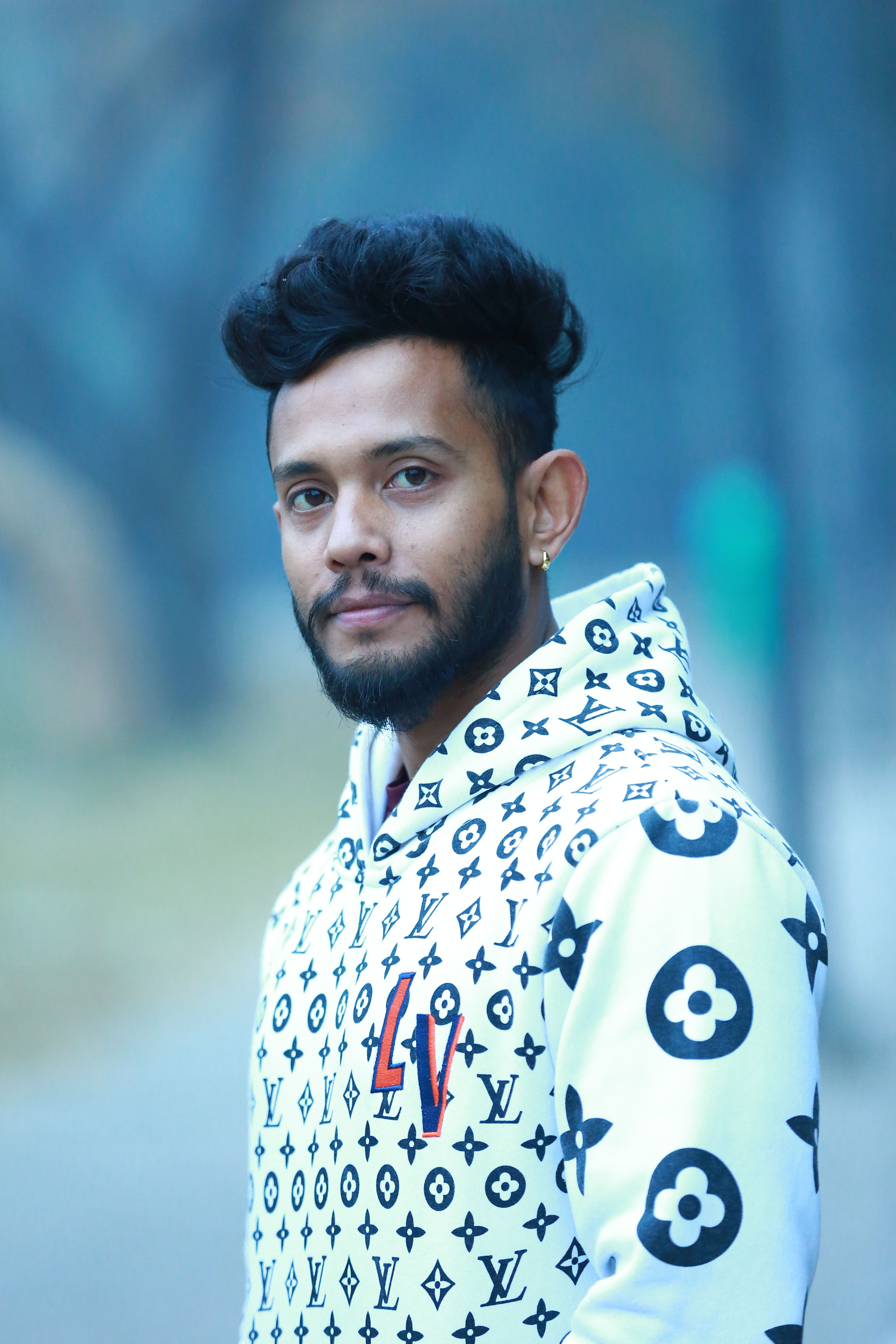 A young man in a fashionable hoodie posing outdoors in Chandigarh, India.