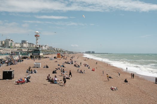 A lively scene at Brighton Beach with people enjoying a sunny day by the sea.