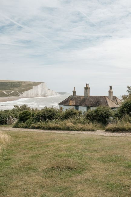 Tranquil rural landscape with cottages and white cliffs at Cuckmere Haven, England.
