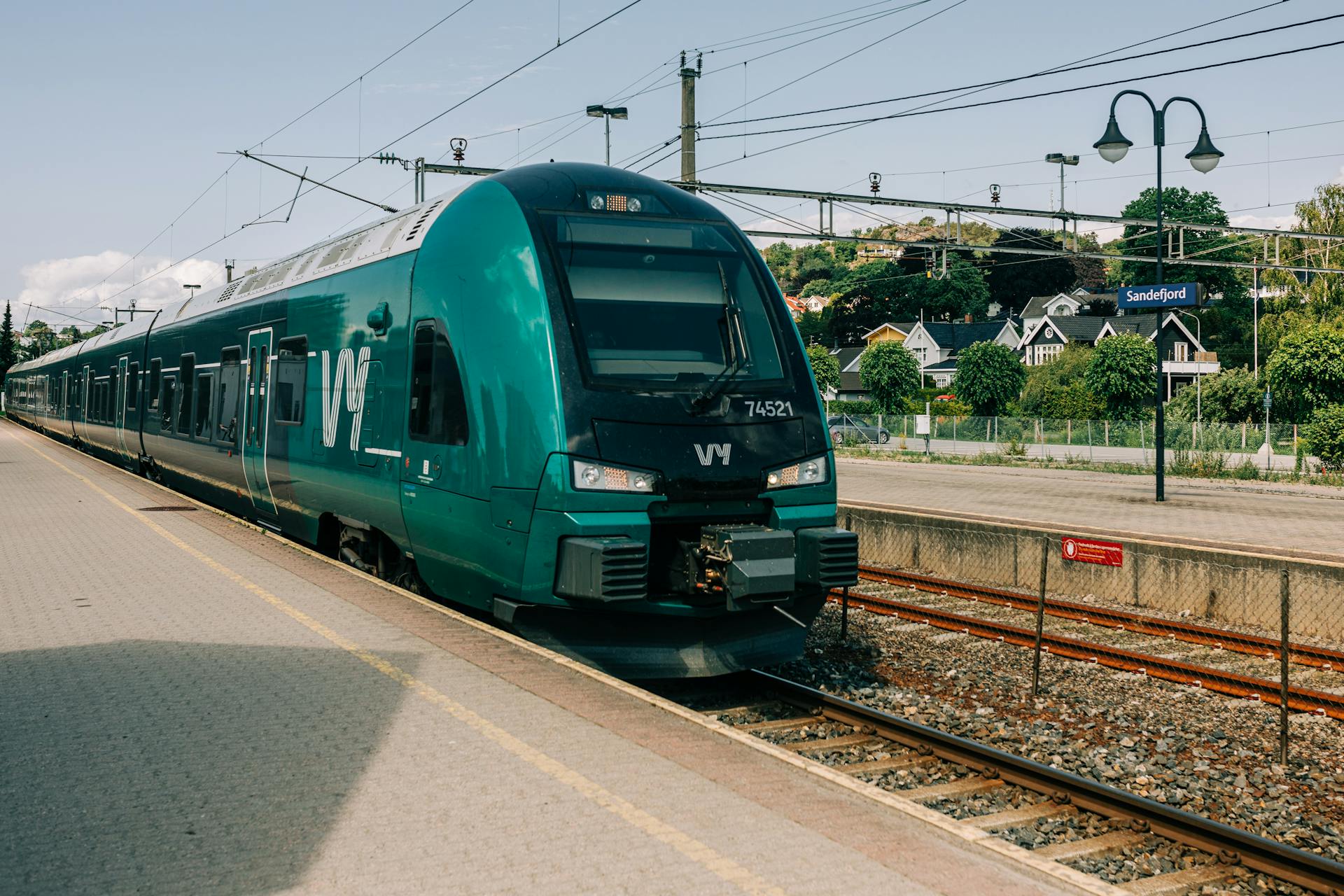 A modern passenger train at Sandefjord station in Norway. Urban transportation captured on a sunny day.