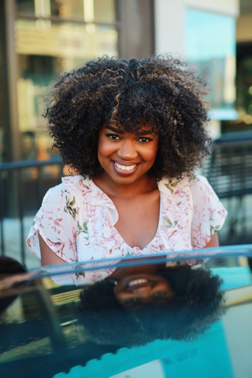 Free Standing Woman Smiling Wearing Floral Blouse Stock Photo