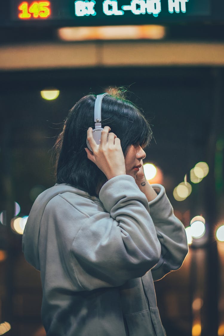 Woman Wearing Headphones At Night