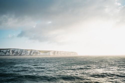 Free Stunning view of the White Cliffs of Dover with vibrant sea and dramatic sunset lighting. Stock Photo