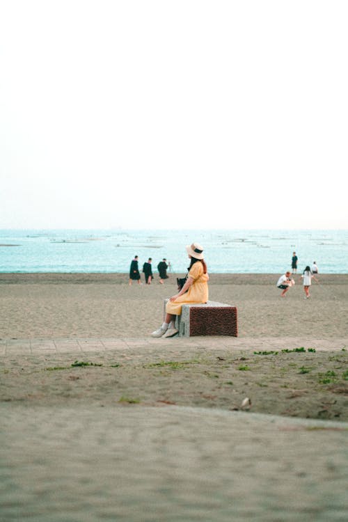 Woman Sitting on Bench on Sea Shore