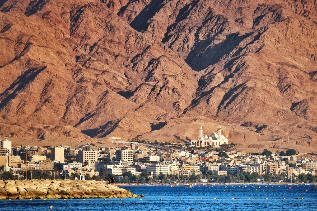 Aqaba waterfront and mosque with red mountains behind