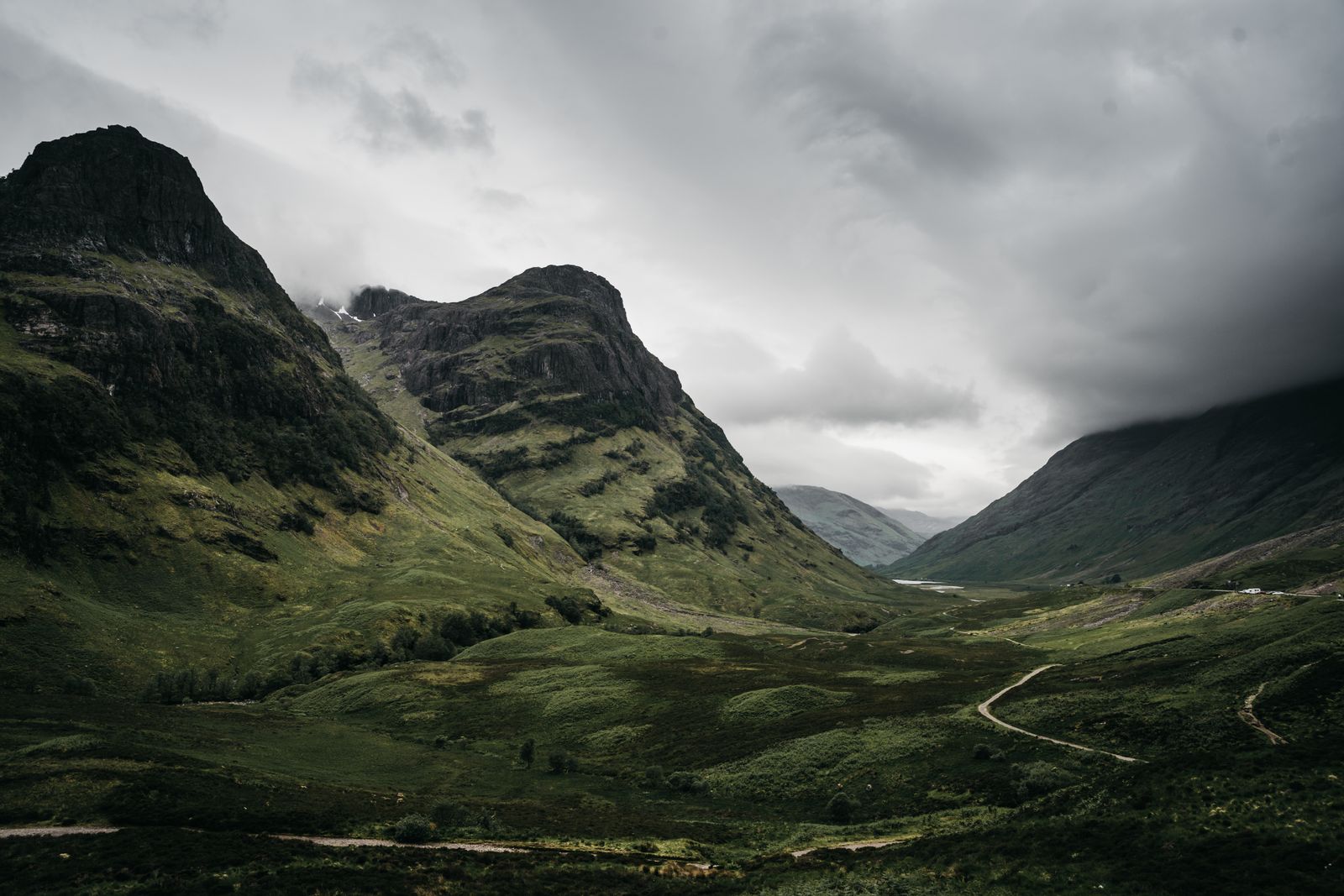 Rugged mountains rising on either side of the Glencoe valley under a cloudy sky