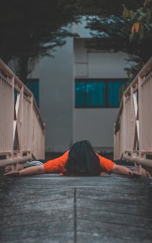 一名穿着橙色衬衫的妇女面朝下躺在狭窄的城市桥梁上