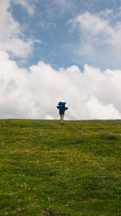 Woman Hiking on Meadow