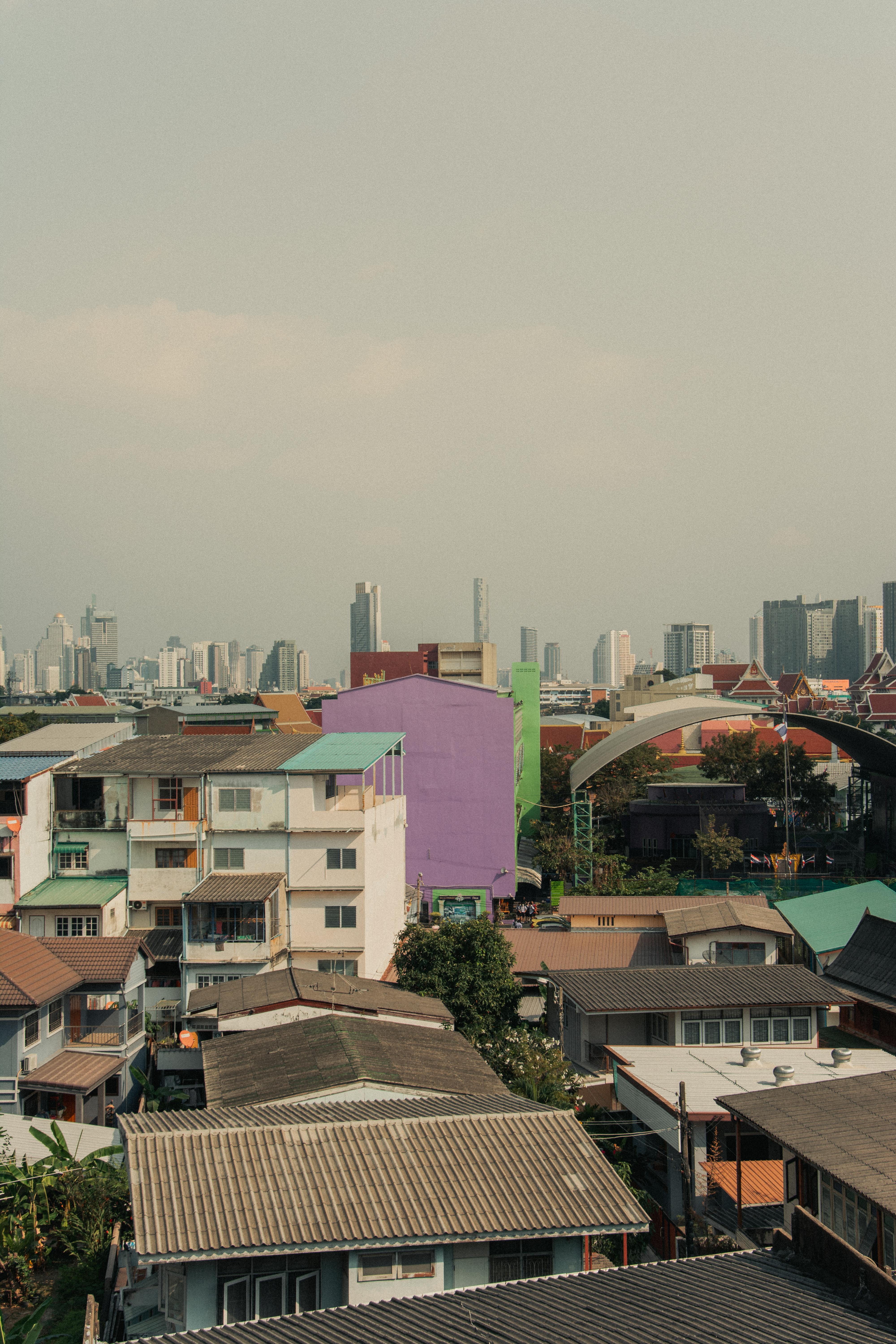 Explore a diverse mix of rooftops and skyscrapers in Bangkok's vibrant urban landscape.
