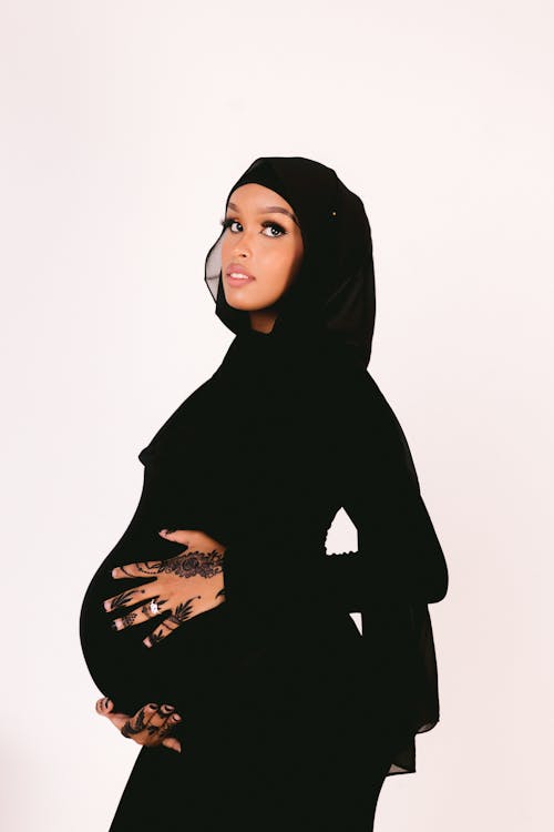 Pregnant Woman in a Black Dress and Headscarf 